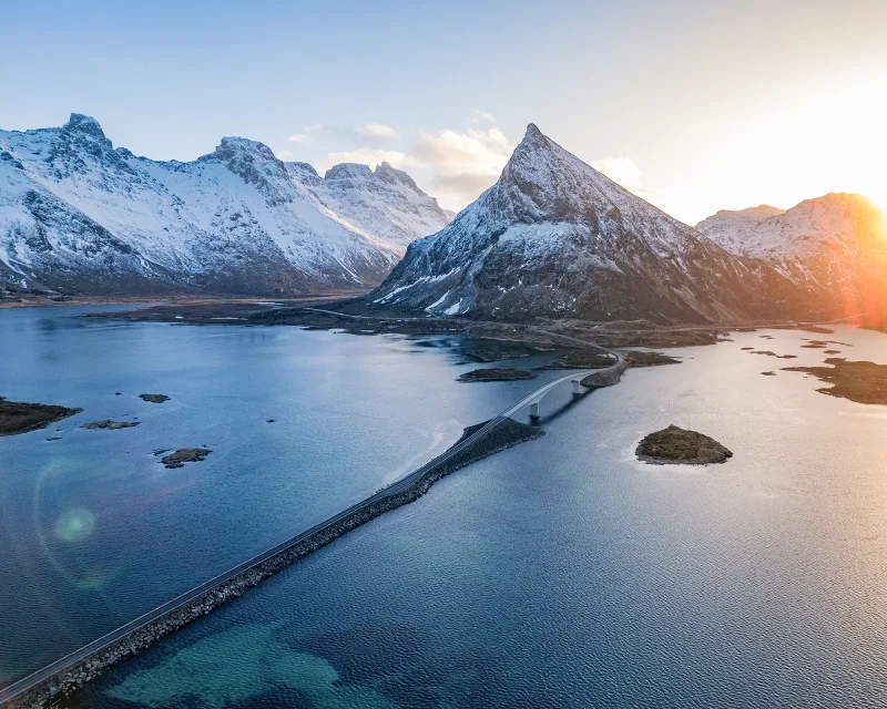 Ein Weg am Wasser zwischen Bergen im Morgenlicht